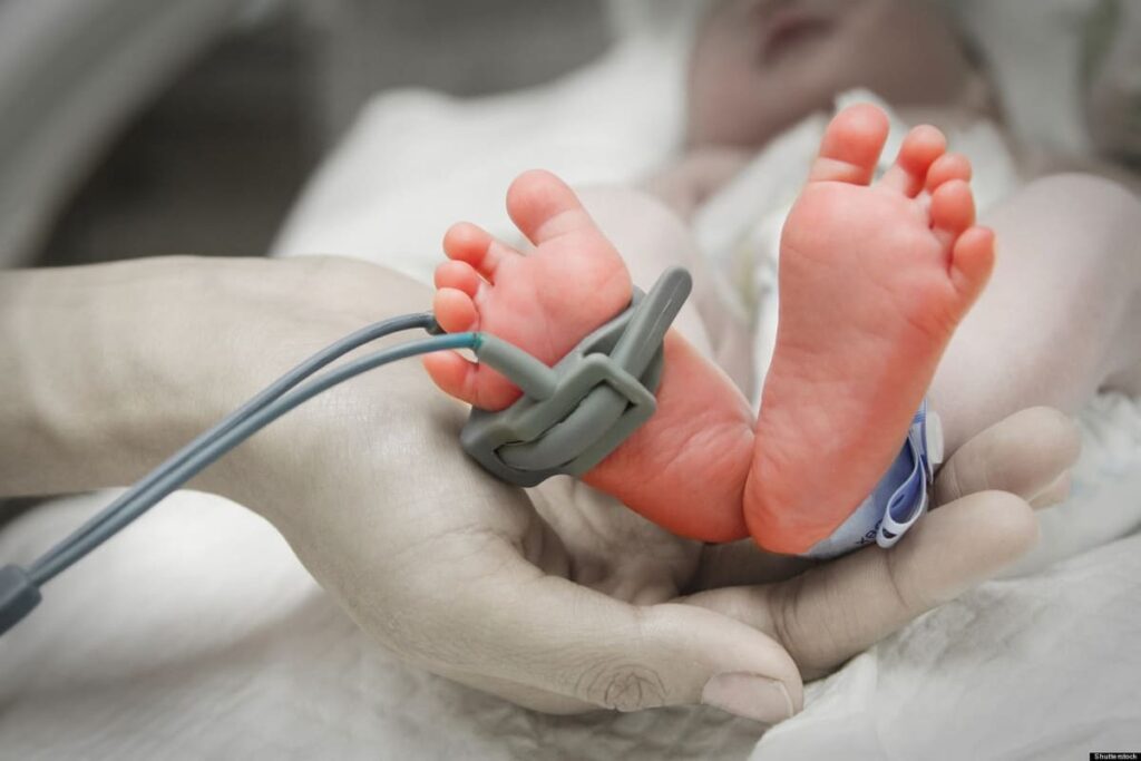 Newborn child undergoing medical evaluation for cancer risk factors